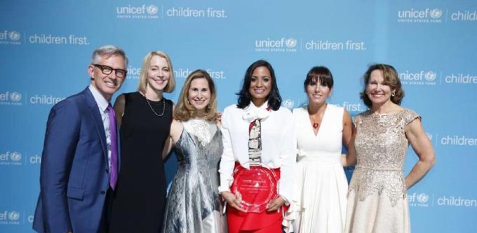 Carolina Martínez, centro, sostiene el galardón “Children´s Champion” que otorga la UNICEF a entidades que se destacan en la protección y defensa de la niñez.