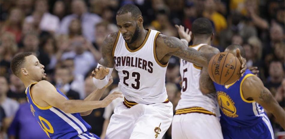 OFENSIVA. LeBron James (23), de Cleveland Cavaliers, y guard Stephen Curry (30), de Golden State, chocan durante el sexto partido de la final entre ambos equipos.