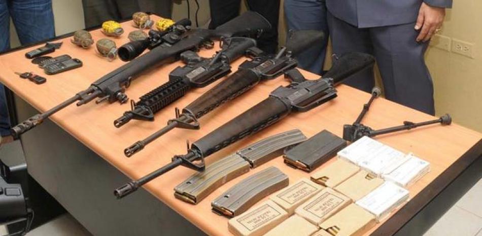 Estos cuatro fusiles, seis granadas y otros accesorios militares mostrados aquí sobre un escritorio estaban en poder, ilegal, de dos hombres en Santiago, a quienes la Policía les incautó durante un operativo en esa ciudad.