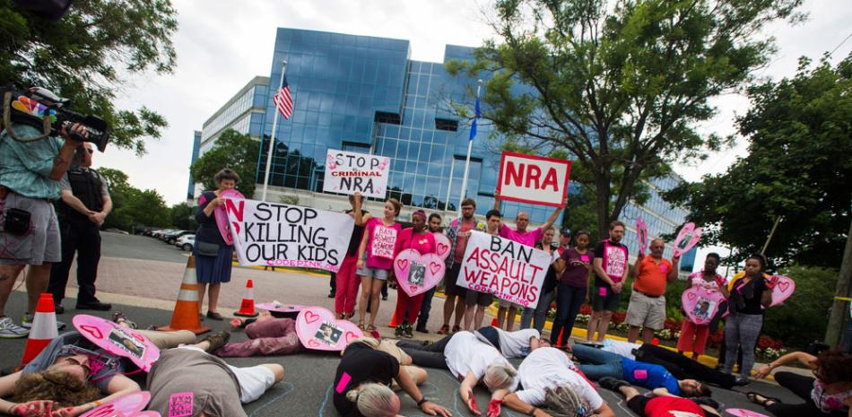 Miembros del grupo pacifista Codepink y otros manifestantes participan hoy en un simulacro en el exterior de la sede de la Asociación Nacional del Rifle (NRA) en Fairfax, Virginia.