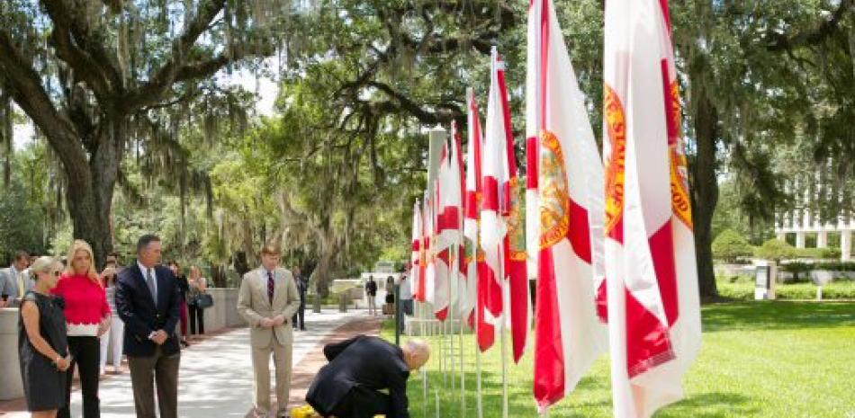 El gobernador de Florida, Rick Scott, depositando unas flores en las afueras del Capitolio Histórico en Tallahassee, Florida.