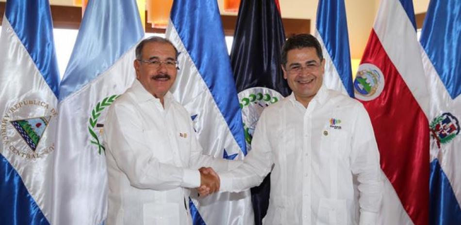 Mandatarios. El presidente Danilo Medina saluda a su homólogo hondureño, Juan Orlando Hernández Alvarado, durante la XLVII Reunión de Jefes de Estado del Sistema de la Integración Centroamericana (Sica), celebradaen Roatán, Honduras.