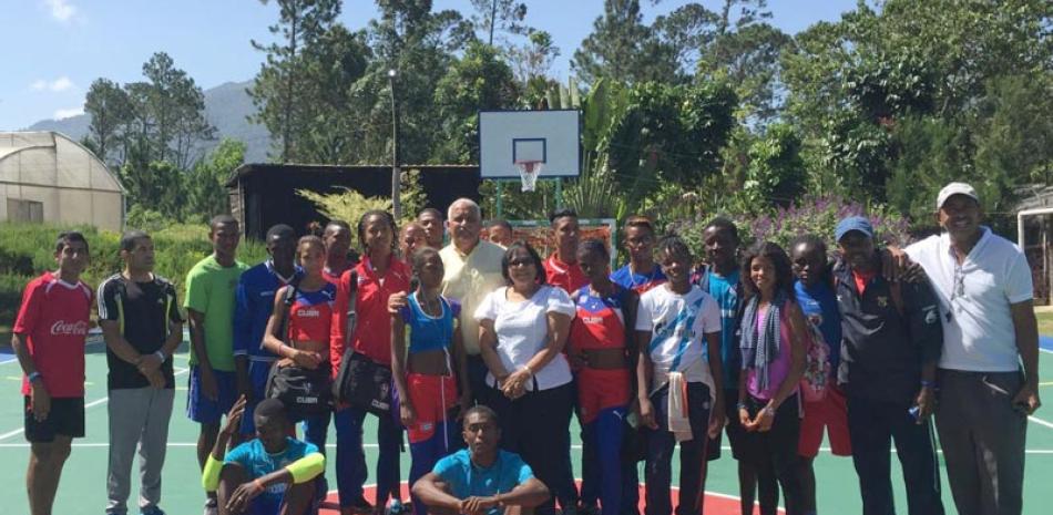 Jaime David Fernández Mirabal y Martha Fernández juntos a un grupo de atletas dentro de la cancha de uso múltiple que fue inaugurada en el municipio de Jarabacoa.