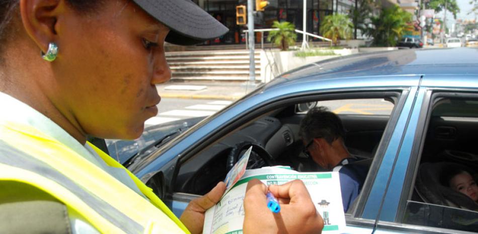 Medida. Una agente de la Amet registra una "multa educativa" a un conductor en una intersección de la capital.