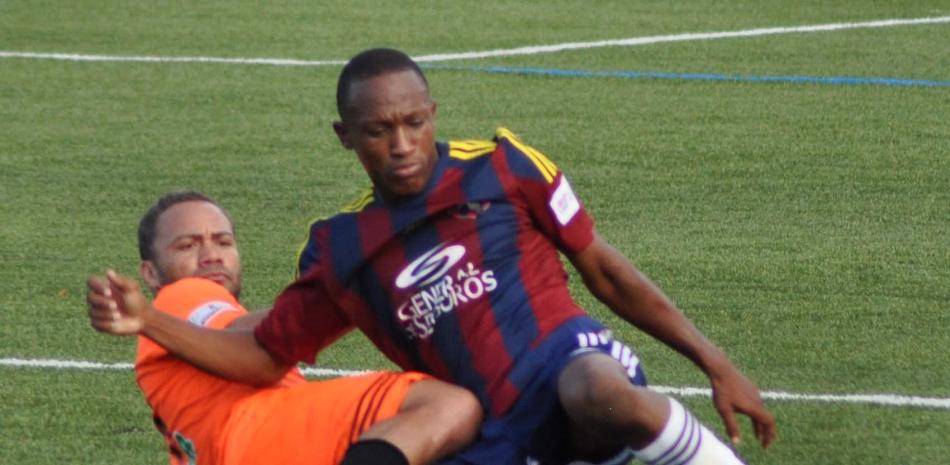 Jonathan Faña, de Cibao, pelea un balón con Wilman Modesta, de Barcelona, durante el partido de este sábado celebrado en el estadio de Cibao FC.