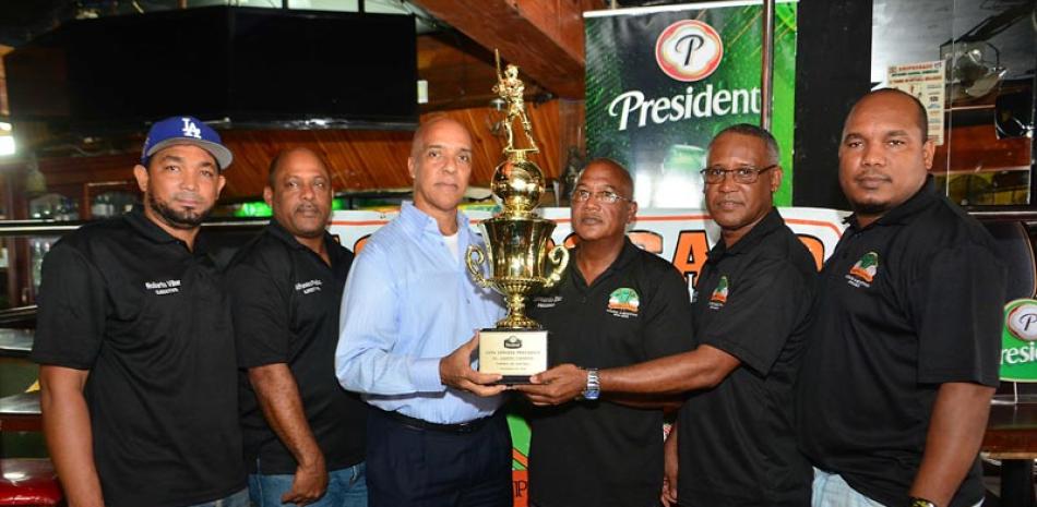 Leonardo Díaz, Manuel Mateo y miembros del comité ejecutivo de Asoprosado sostienen la copa Cerveza Presidente que estará en juego durante el torneo molichata.
