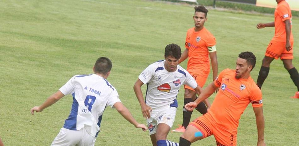 Ofensiva. El defensor Sergio Alonso, de San Cristóbal, y César García, del Cibao, disputan el balón.