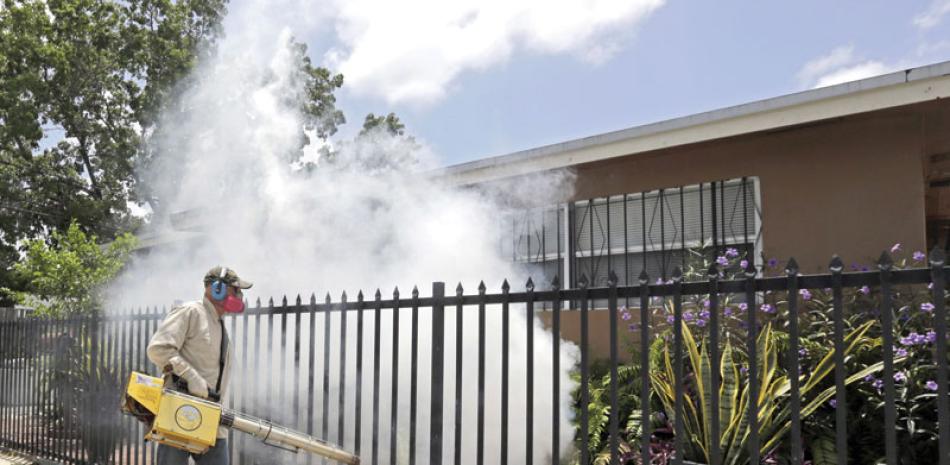 Fumigación. Un trabajador de plagas del Condado Miami-Dade, fumiga una casa en el área de Wynwood, en Miami, ayer.