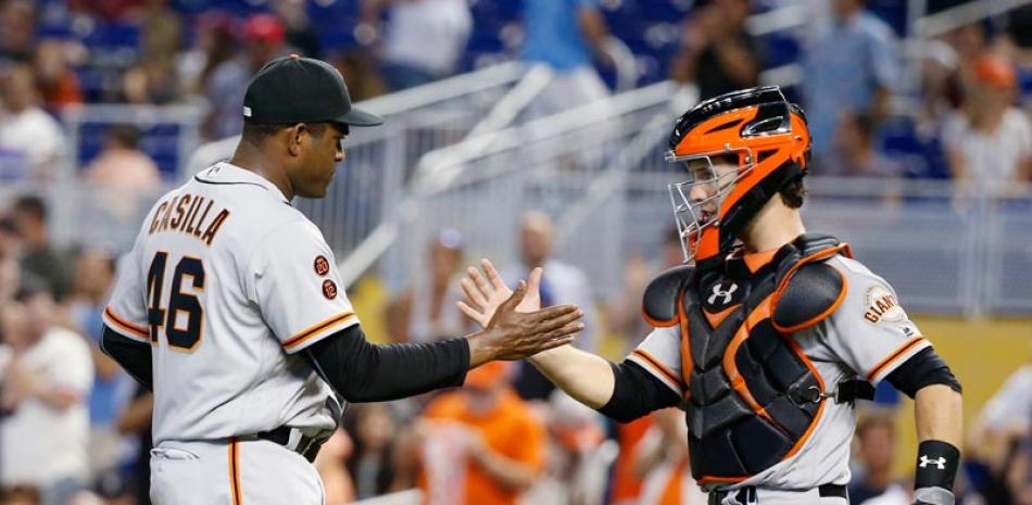 Santiago Casilla y el catcher Buster Posey celebran luego de la victoria de ayer de los Gigantes de San Francisco sobre los Marlins de Miami.