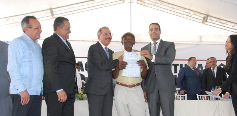 El presidente Danilo Medina y el director de la Comisión Permanente de Titulación de Terrenos del Estado, José Dantés Díaz, en la entrega de títulos.