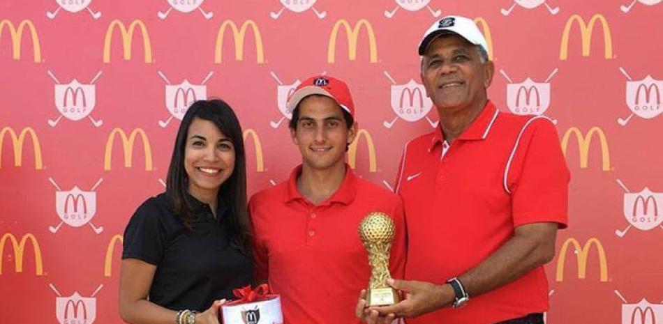 Enrique José Valverde recibe un trofeo por parte de Rafael Villalona y la representante de McDonald’s.