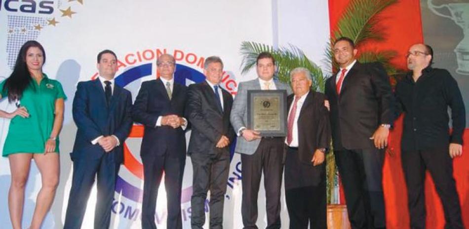 Adrianito Abreu, junto a su padre Adriano Abreu, recibe el galardón de Automovilista del Año en compañía de José Rafael Liz, presidente de FDA, Miriam Batista y otros directivos de la entidad.