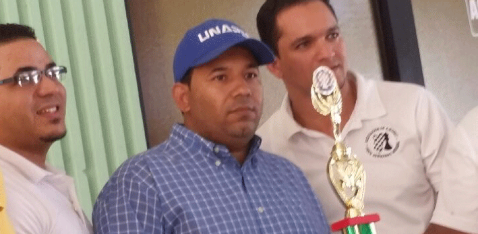 Janier Rosado premia a Braulio Ramírez, le acompaña Julián Flete Ynoa, presidente de la Asociación de Ajedrez de Salcedo.