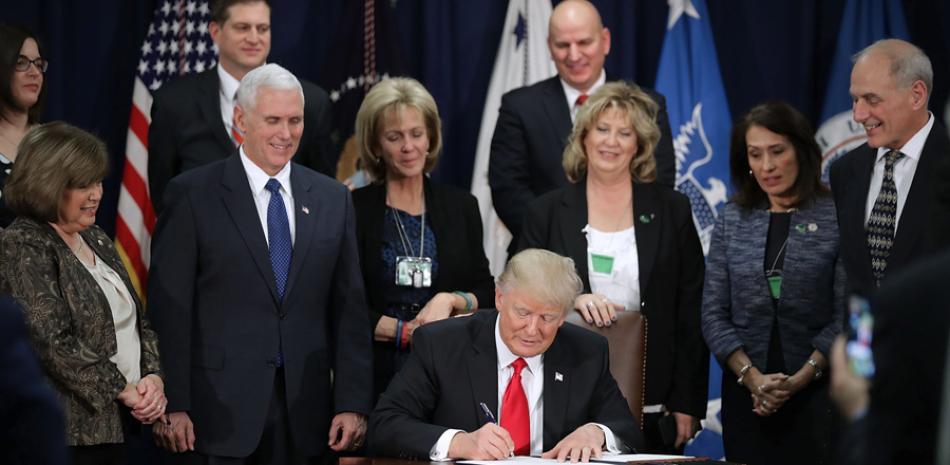 Presidente. Donald J. Trump firma la orden ejecutiva para destinar fondos federales a la construcción del muro en la frontera con México durante una ceremonia ayer en el Departamento de Seguridad Nacional en Washington, Estados Unidos.
