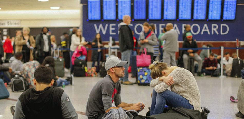 Pasajeros varados en el aeropuerto de Atlanta (Georgia) descansan sentados en el suelo este pasado domingo.