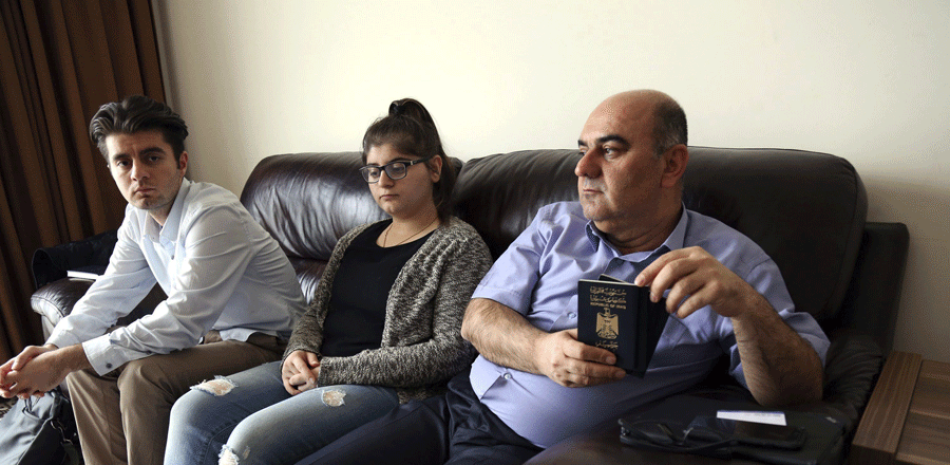 Fraud Sharif (d), de 51 años, enseña junto a los miembros de su familia su pasaporte en su residencia en Erbil, la capital de la Región Autónoma Kurda, al norte de Irak, hoy 31 de enero de 2017.