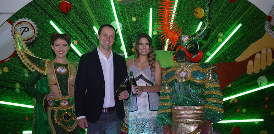 Felipe Ambra y Melissa Martínez, junto a personajes del carnaval Presidente.