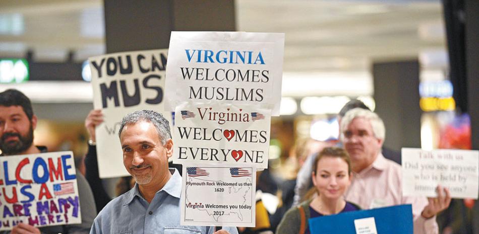 Bienvenidos. Viajeros internacionales reciben la bienvenida por manifestantes en el Aeropuerto Internacional Dulles, en Sterling, Virginia, luego de que un juez federal impidiera temporalmente la aplicación del veto migratorio del presidente Donald Trump.