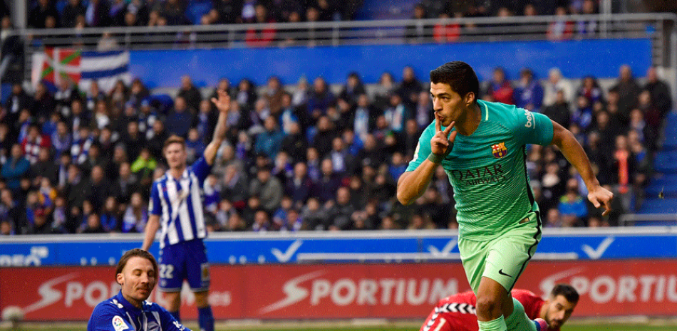 El uruguayo del FC Barcelona, Luis Suárez, celebra su gol frente al arquero del Alavés, Fernando Pacheco, durante el duelo de la Liga en el estadio Medizorroza de Vittoria, España.
