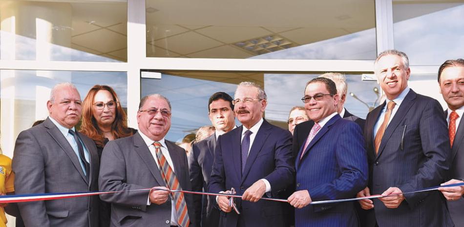 Danilo Medina y Rafael Ovalles mientras realizaban el corte de cinta junto a los demás funcionarios.
