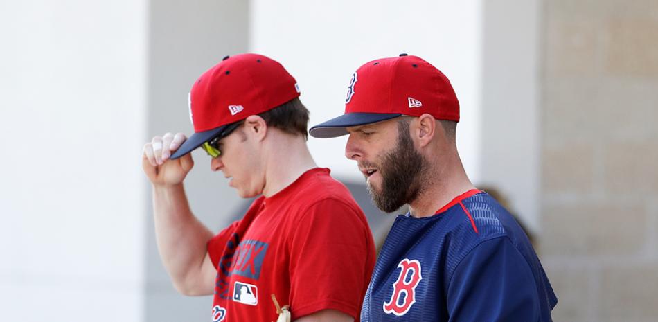 Dustin Pedroia, el estelar intermedista de Boston, se dirige al campo junto al utility Brock Holt