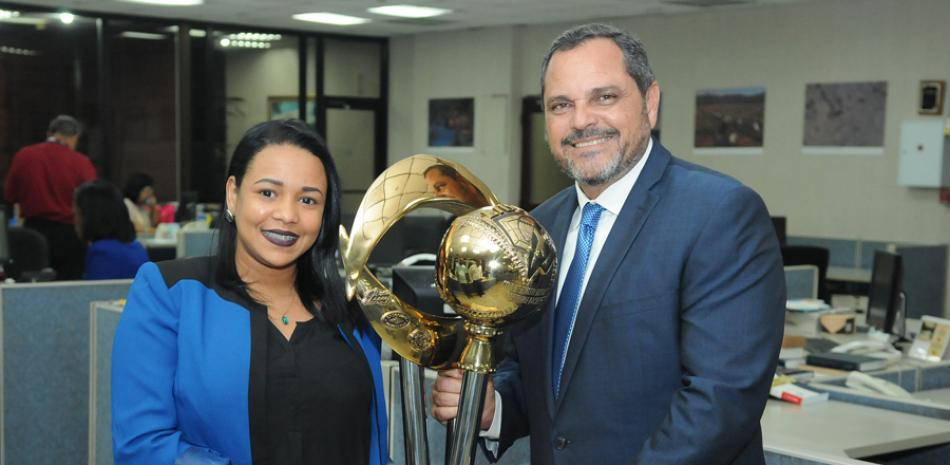 Junior Noboa, gerente general del Licey posa con el trofeo con la periodista Ambar Méndez, miembro del staff de Listín Diario Digital.