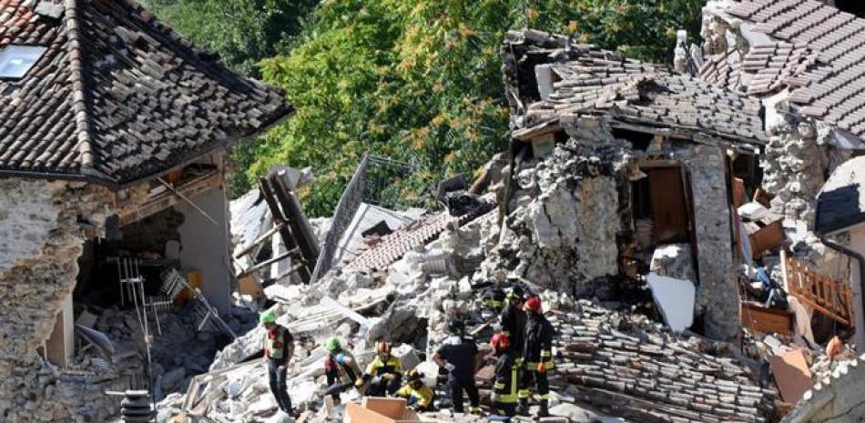 Los miembros de los servicios de rescate trabajan en la búsqueda de supervivientes entre los escombros en Pescara del Tronto, centro de Italia, el 25 de agosto de 2016.