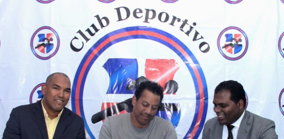 Dereck Baker López firma su contrato de trabajo junto al presidente del club San Lázaro, Milton Díaz, y el gerente general, Fernando Gómez.