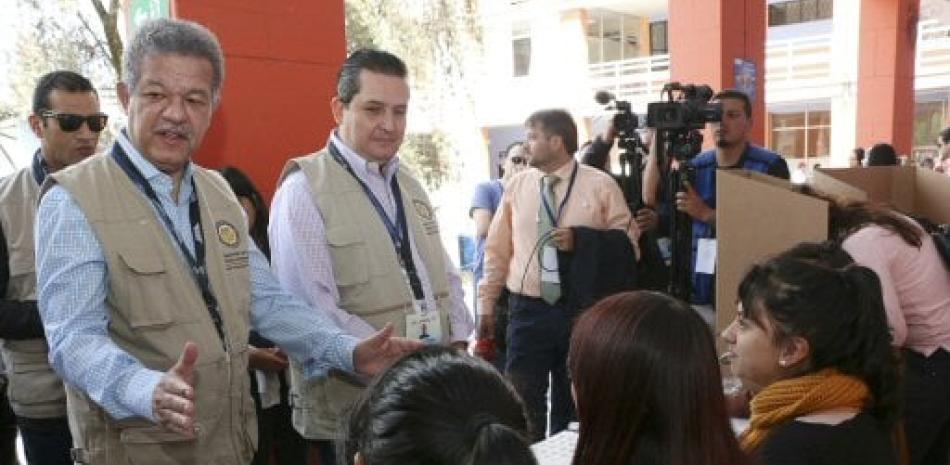 El jefe de la Misión Electoral de la Organización de Estados Americanos (OEA), el expresidente dominicano Leonel Fernández, habla con algunos jurados en un puesto de votación, en Quito (Ecuador).
