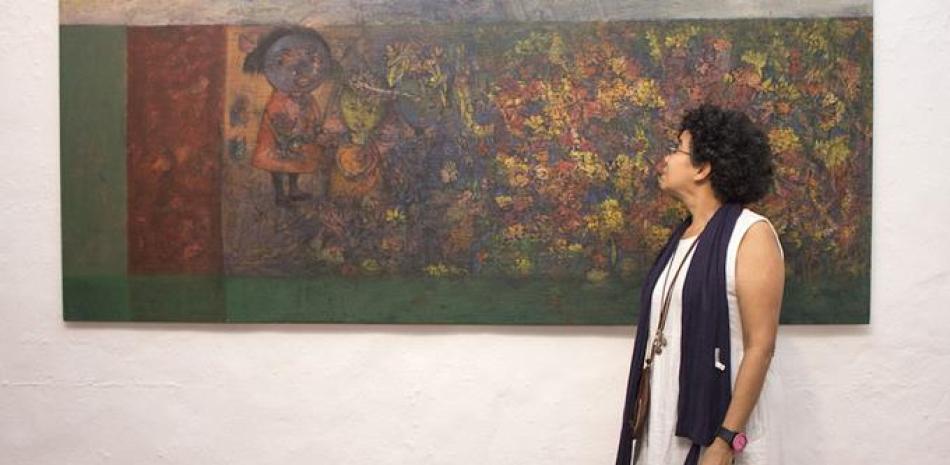 Imagen. La artista contempla una de las obras que conforman su más reciente propuesta, que está en la galería de artes de Altos de Chavón.