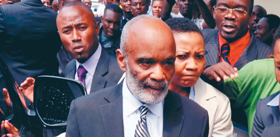 Tribunal. En foto del 7 de marzo de 2013, el exmandatario René Preval, al centro, sale de un tribunal luego de una audiencia en Puerto Príncipe.