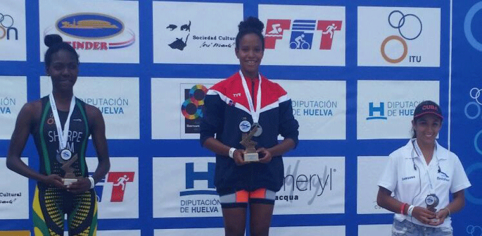 La dominicana Camila Romero, al centro, quien conquistó la medalla de oro categoría junior del Campeonato Iberoamericano de Triatlón, en La Habana, Cuba. En los extremos, La jamaiquina Llori Sharp y la cubana Daily Marrero, segundo y tercer lugar.