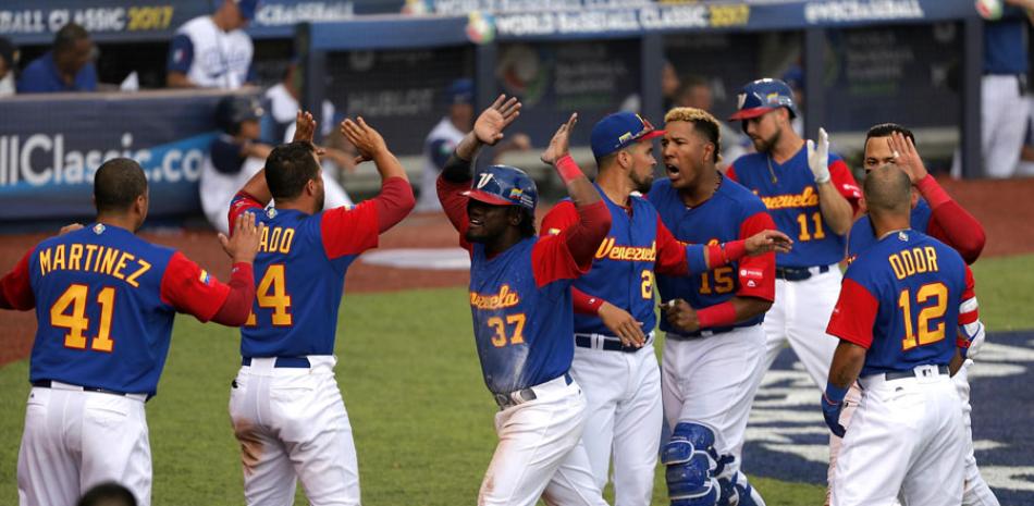 Jugadores de Venezuela celebran tras anotar una carrera en el choque que le ganaron a Italia.