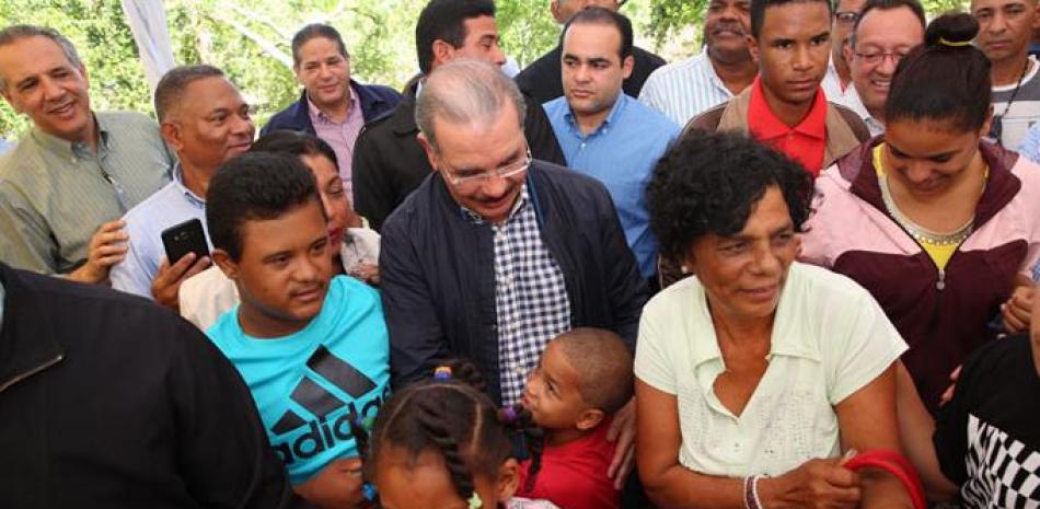 Saluda. El presidente Danilo Medina rodeado de funcionarios y colaboradores cuando compartía con familias asociadas que impulsan un proyecto ganadero de integración de discapacitados.