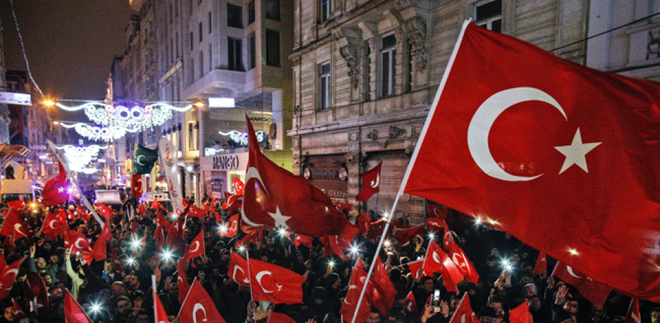 Manifestantes ondean banderas frente al consulado holandés en la avenida Istiklal del centro de Estambul, la principal vía comercial de la ciudad, la madrugada del domingo 12 de marzo de 2017.