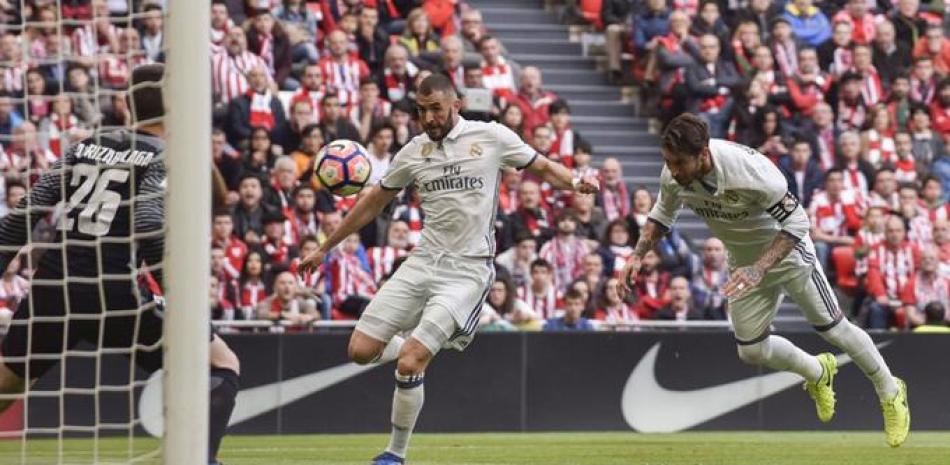 Karim Benzema, del Real Madrid, al centro, observa el balón en su ruta hacia la porteria junto a su compañero Sergio Ramos durante el partido contra el Athletic de Bilbao en el estadio San Mamés.
