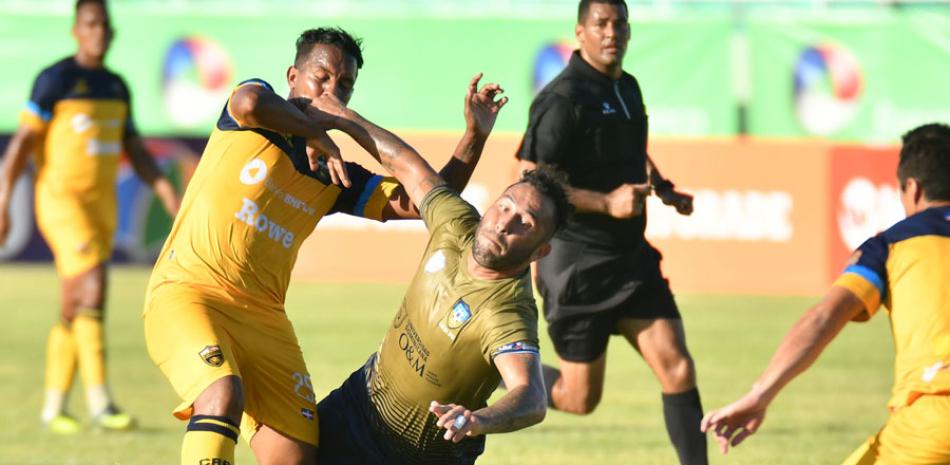 Anderson Arias, de la Universidad O&M, se abre paso ante varios jugadores del Atlético Pantoja, durante el partido de este domingo en el estadio olímpico Félix Sánchez. Arias marcó dos goles.