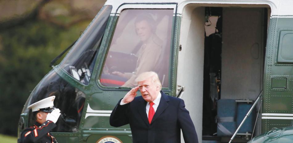 Retorno. El presidente Donald Trump saluda mientras desciende del Marine One, en la Casa Blanca, ayer, luego de su viaje a Mar-a-Lago, en Palm Beach, Florida.
