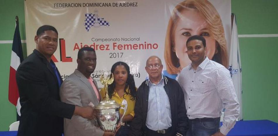 Wily González, presidente de la Federación Dominicana de Ajedrez, acompañado de Carlos del Rosario, Luis Lorenzo y Luis Brito entregan la gran copa Grupo Corripio a Jennifer Almánzar nueva campeona nacional de ajedrez superior femenino.