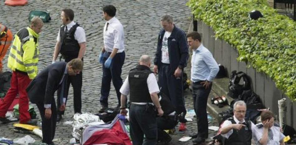 El parlamentario conservador Tobias Elwood, izquierda, entre los rescatistas en la escena del ataque cerca del Parlamento británico, Londres, miércoles 22 de marzo de 2017. (Stefan Rousseau/PA via AP).