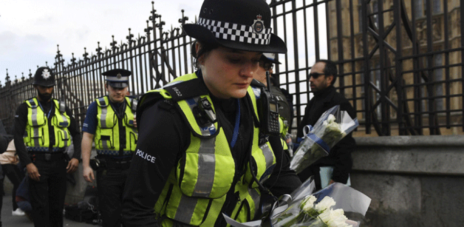 Policías depositan flores cerca del Parlamento en Londres, Reino Unido, hoy 23 de marzo de 2017. Siete personas han sido detenidas en el registro de seis direcciones en Londres, Birmingham y otros lugares del país no especificados con relación al atentado terrorista ocurrido ayer en Westminster que dejó cinco personas muertas, incluida el atacante, y unas 40 heridas. EFE/Andy Rain