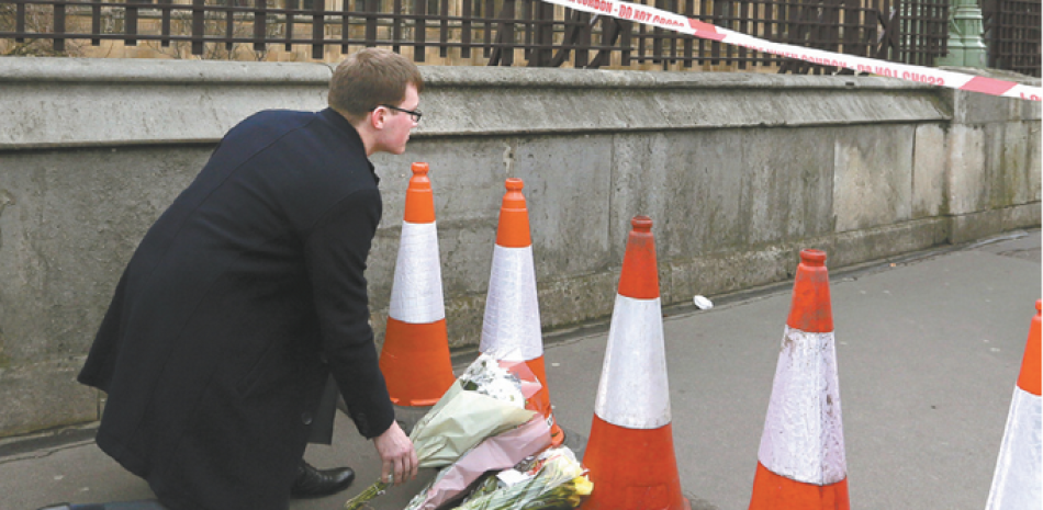 Honor. Un londinense coloca flores como tributo a las víctimas del ataque del miércoles, ayer.