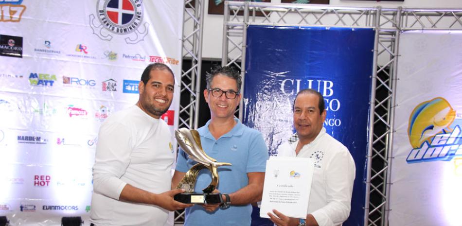 El comodoro del Club Náutico de Santo Domingo Josie Pérez junto al director del XLIV torneo de pesca El Dorado, premian a Jonathan Liriano, ganador de la justa.