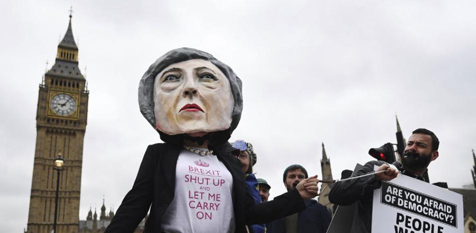 Protesta. Una manifestante disfrazada de la primera ministra británica, Theresa May, posa junto a otros que sostienen una pancarta que reza “¿Tienes miedo a la democracia?, ayer en Londres.
