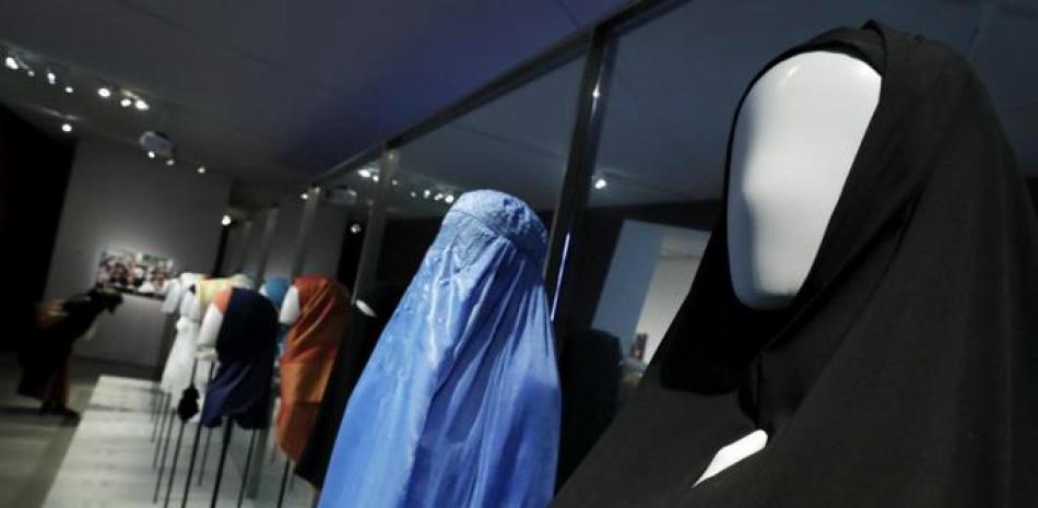 Una mujer observa diferentes obras en la exposición "Cherchez la femme: Wig, Burqa, Wimple" (en busca de la mujer: peluca, burka, griñon) del Museo Judío de Berlín (Alemania) hoy, 30 de marzo de 2017. La exposición, que muestra los motivos históricos y religiosos de las mujeres para cubrirse la cabeza tanto en el judaísmo como en el islam y el cristianismo, abrirá mañana sus puertas hasta el próximo 2 de julio. (EFE/Felipe Trueba)