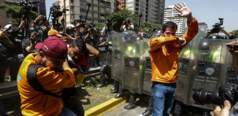 Gases. El diputado José Guaidó (d) es afectado por gas lacrimógeno frente a integrantes de la Policía Nacional Bolivariana (PNB) durante una manifestación ayer, que intentaba marchar hacia el Parlamento en apoyo a la destitución de los magistrados del Supremo.