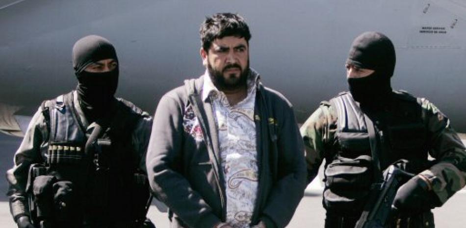 En esta foto de archivo del 21 de enero de 2008, policía federal de México escolta a Alfredo Beltrán Leyva, alias “El Mochomo”, después de su arresto a su llegada al aeropuerto de Ciudad de México.