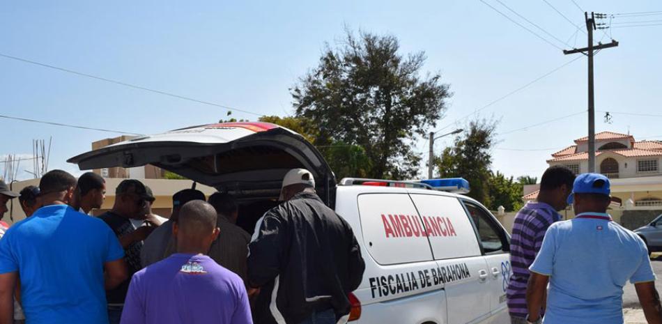 Parientes de Juan Carlos Joel Féliz, sacan en el ataúd con su cadáver para introducirlo en la ambulancia de la Fiscalía a los fines de trasladarlo a la Regional del INACIF en Azua