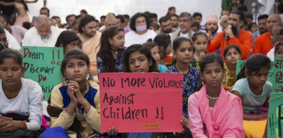 Los niños indios tienen pancartas condenando los recientes ataques químicos en Siria y casos de violencia contra niños en todo el mundo durante una reunión de paz en el monumento Mahatma Gandhi en Nueva Delhi, India, el lunes 10 de abril de 2017.