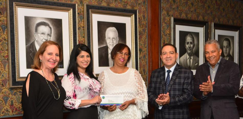 Reconocimiento. La editora de Economía y Negocios recibe de la mano de los miembros de la Cámara Minera de República Dominicana el premio que la acredita como ganadora.